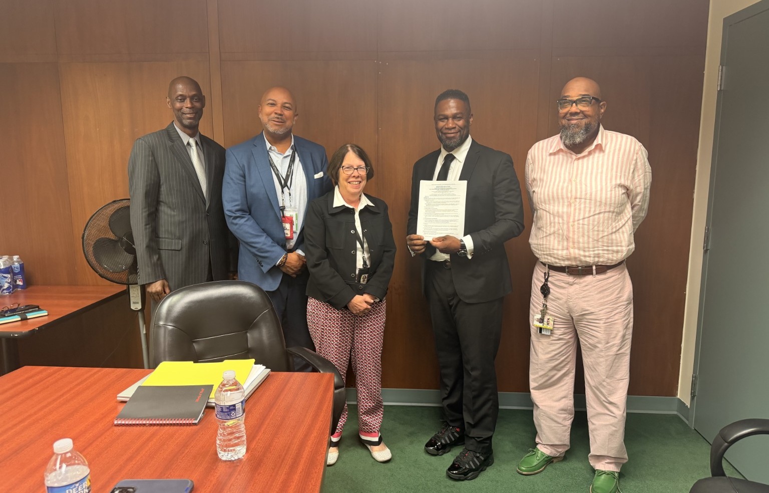 Agency and Local representatives standing together with the negotiated Assistant Superintendent side letter